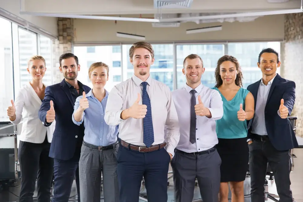 Hire the Right Staff for Your Needs for Health for Child and Adult A team of professionals, dressed in business attire, all smiling and giving a thumbs-up, signifying satisfaction and success in staffing for health care.
