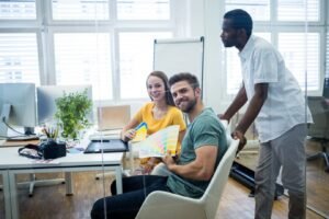 Professional Collaboration for Tailored Health Care Solutions A diverse team of professionals in an office setting, collaborating and discussing strategies for health care management.