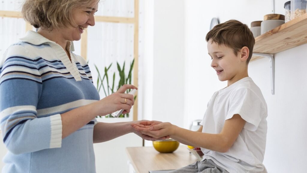 A woman stands next to a boy indoors instructed for Care, both dressed in casual clothing, with a wall visible in the background.