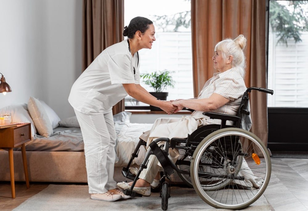Caregiver Assisting Elderly Woman in a Wheelchair A caregiver and an elderly woman share a warm moment as the caregiver helps the woman in a wheelchair, offering support and companionship.